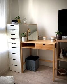 a wooden desk with drawers and a mirror on top of it next to a window