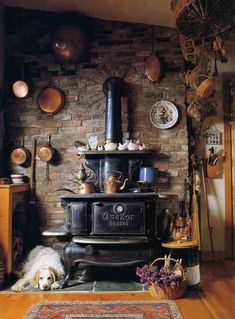 an old fashioned stove in the corner of a room filled with pots and pans