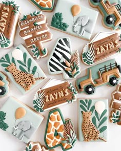 decorated cookies are arranged in the shape of giraffes, zebras and elephants