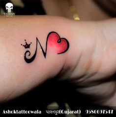 a woman's arm with a heart and crown tattoo on it