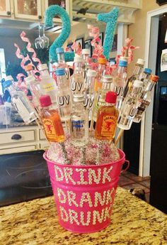 a pink bucket filled with bottles on top of a counter