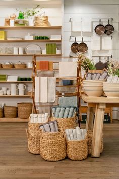 baskets are stacked on the floor in front of shelves with dishes and utensils