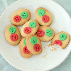 some cookies are on a white plate with green and red icing that says n is for n