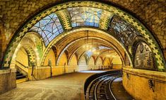 the inside of a train station with lots of windows and lights on it's ceiling