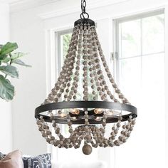 a chandelier with beads hanging from it's center piece in a living room