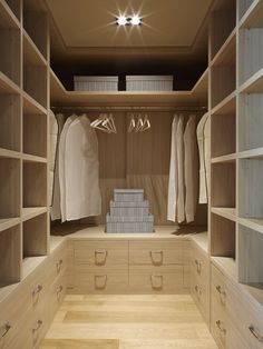 a walk in closet filled with lots of wooden shelves