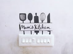 a kitchen wall with the words mum's kitchen on it and utensils