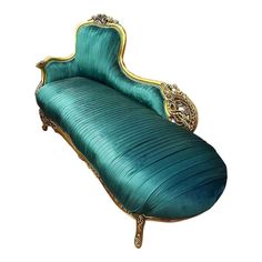 a green couch with gold trimmings sitting on top of it's legs