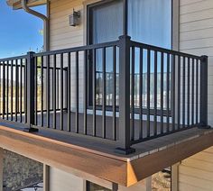 a balcony with black iron railings on the side of a house