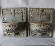 two metal pots with crosses on them sitting next to each other