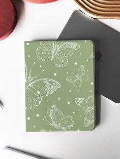 a green notebook with white butterflies on it