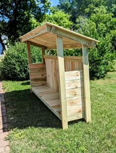 a small wooden outhouse sitting in the grass