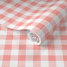 a red and white checkered tablecloth with a roll of paper on top of it