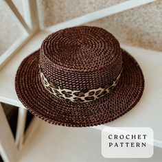 a brown hat sitting on top of a white table next to a wall with the words crochet pattern