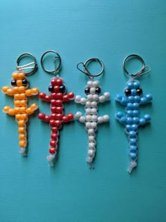 three keychains made out of beads on a blue surface