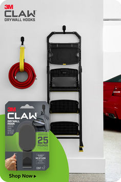 a red car is parked next to a ladder with tools on it and an ad for clam