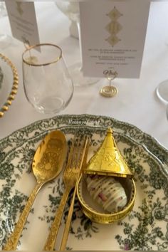 there is a plate with gold decorations on it and two forks next to the plates