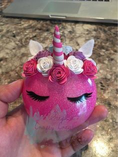 someone is holding a pink unicorn ball with flowers on it