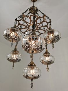 an ornate chandelier with glass globes hanging from the ceiling