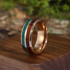 a wooden ring with two different colored wood inlays on top of a piece of wood