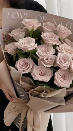 a woman holding a bouquet of pink roses