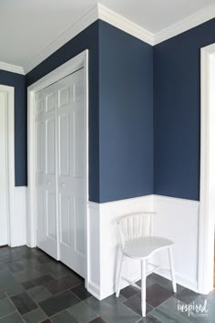 a white chair sitting in the corner of a room with blue walls and tile flooring