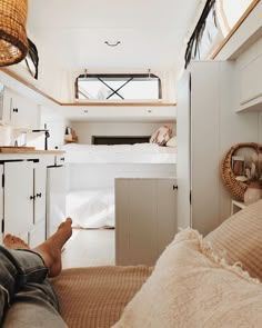 a person laying on the floor in a room with bunk beds and white cupboards