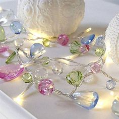 a white plate topped with lots of different colored glass beads and lights on top of it