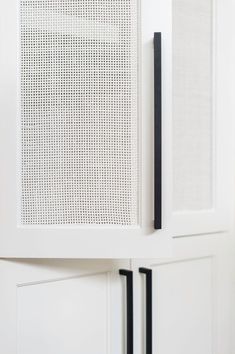 a white cabinet with black handles and doors