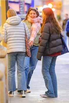 two women walking down the street talking to each other