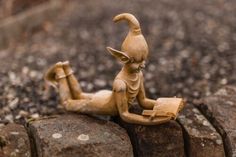 a small statue sitting on top of a rock