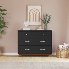 a black dresser sitting in a living room next to a potted plant