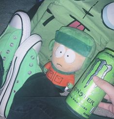 a person holding a can and a toy in their lap with the simpsons character on it