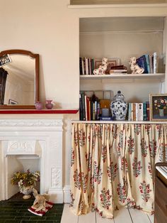 a living room filled with furniture and a fire place under a mirror next to a fireplace