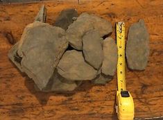 a measuring tape and some rocks on a wooden table next to a yellow plastic object