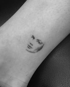 a black and white photo of a person's arm with a smiley face on it