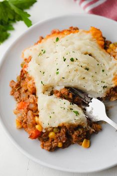 a white plate topped with mashed potatoes and ground beef covered in gravy