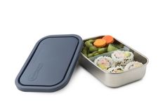 a small metal container filled with sushi and vegetables next to a blue lid on a white background