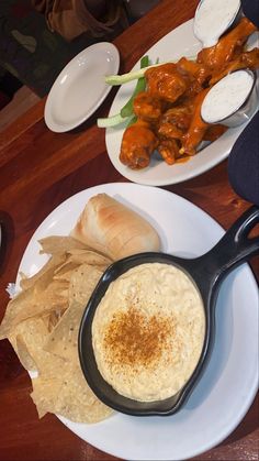 a plate with some food on it next to a bowl of dip and pita bread