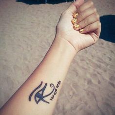 a woman's arm with a tattoo on it that reads k and has the letter k in black ink