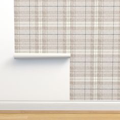 an empty room with plaid wallpaper and wooden flooring