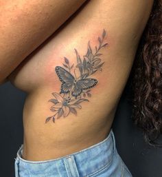 a woman's stomach with a butterfly tattoo on her left side ribcage