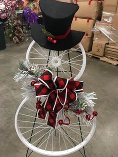 a bicycle wheel with a top hat and bow tie attached to the front wheel, sitting in a warehouse