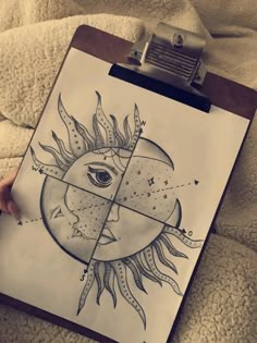 a person holding up a clipboard with a drawing of a sun and moon on it