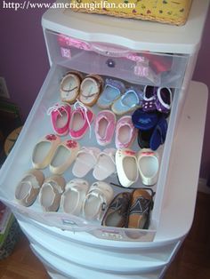 an open refrigerator filled with lots of baby shoes and slippers on top of it