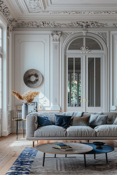 an elegant living room with white walls and wood flooring is decorated in blue and gray