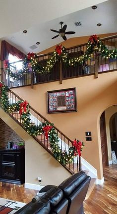 the stairs are decorated with christmas garlands and poinsettis for holiday decor