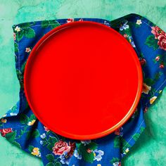 a red plate sitting on top of a blue cloth