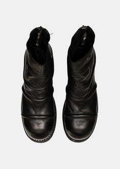 a pair of black leather boots on a white background