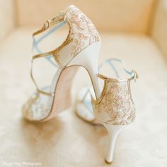 a pair of white high heeled shoes sitting on top of a table